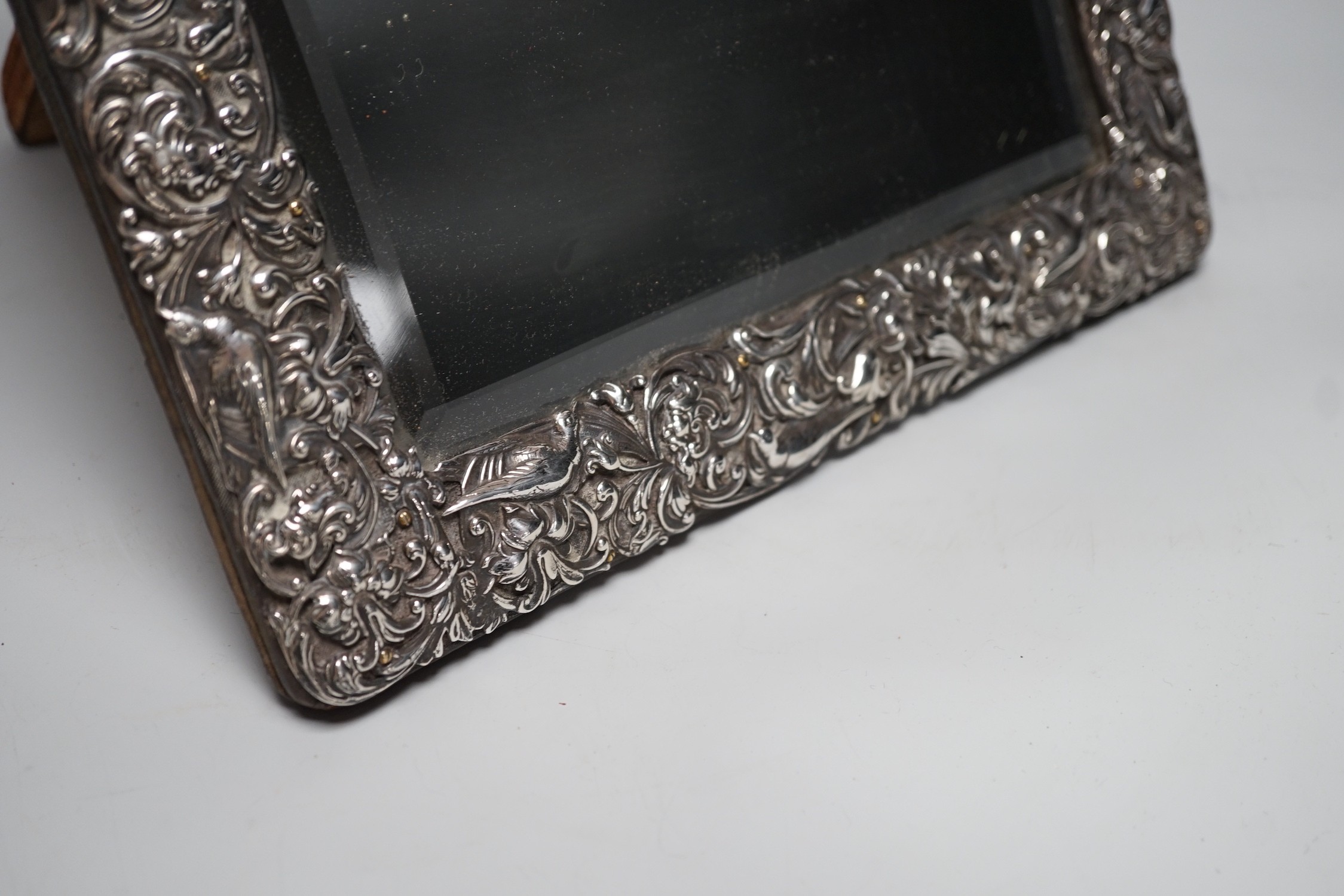 A late Victorian repousse silver mounted rectangular easel mirror, William Comyns, London, 1900, 39.8cm.
